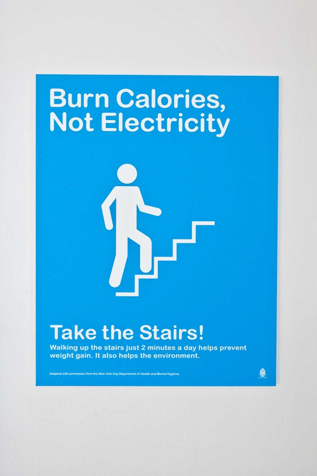 Customized signage suggests you take the stairs...