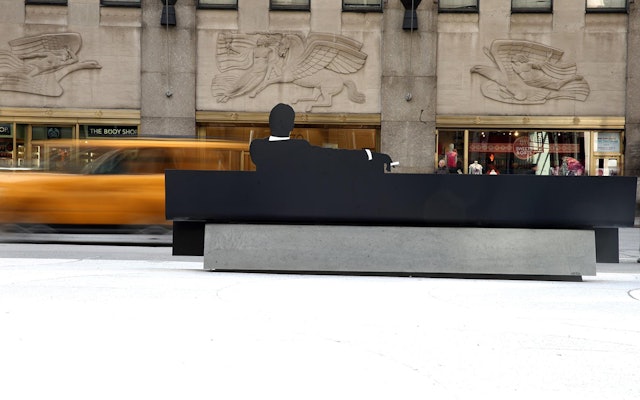 The bench is located in front of the Time & Life Building, fictional home of Sterling Cooper Draper Pryce.