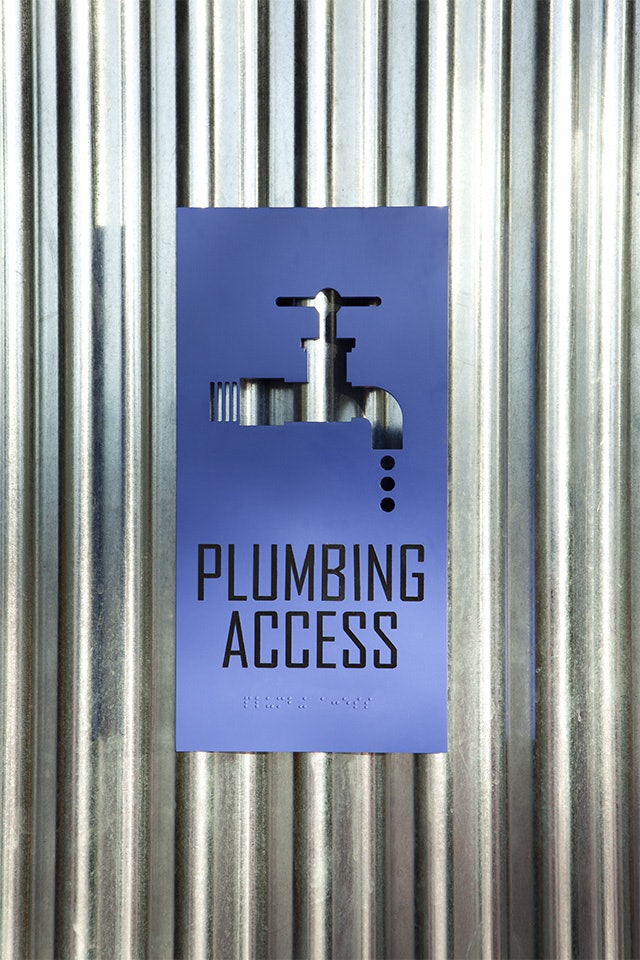Facilities building signage features colorful aluminum plaques with icon cutouts.