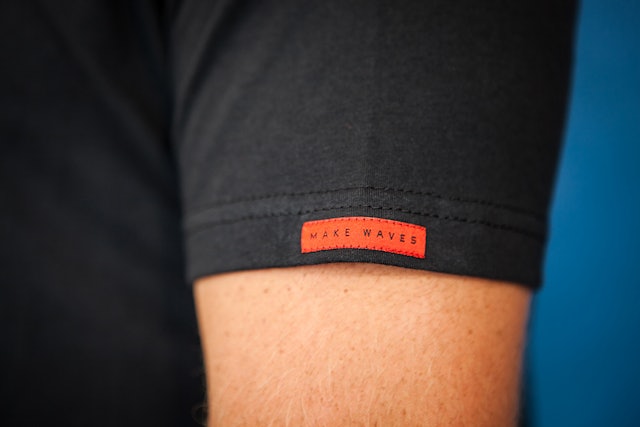 The “Make Waves” tagline patch on a t-shirt.
